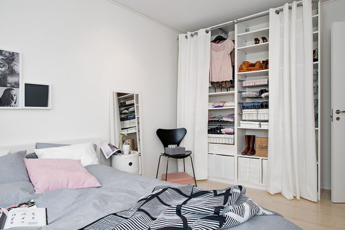 petite chambre avec dressing derrière des rideaux