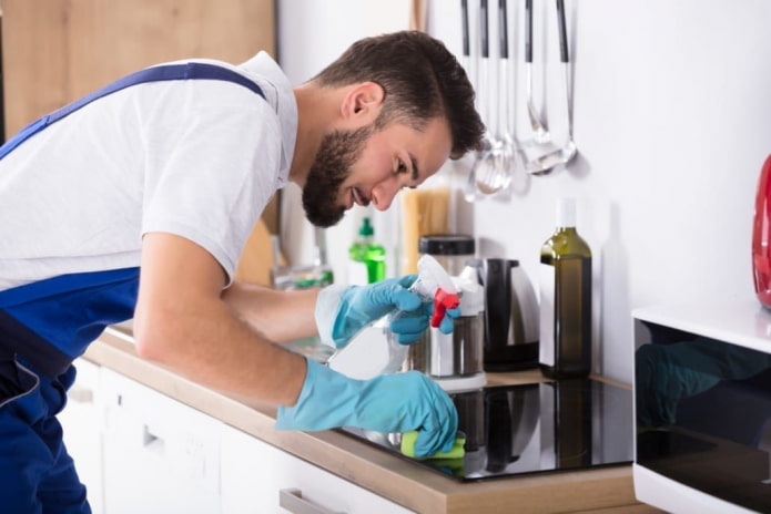 l'homme essuie la cuisinière électrique