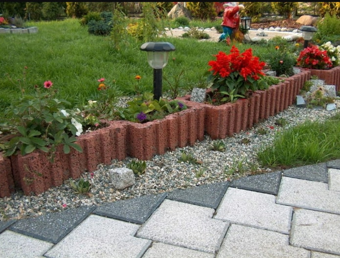 clôture de jardin fleuri en blocs de béton rouge