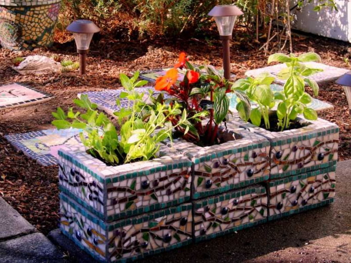 mini-flower bed na gawa sa kongkreto na mga bloke, pinalamutian ng mga shard ng tile