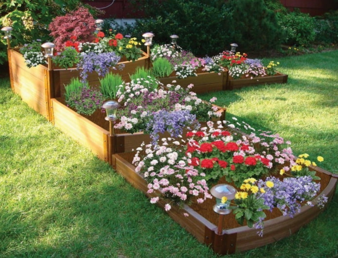 parterre de fleurs à trois niveaux avec côtés en bois et éclairage