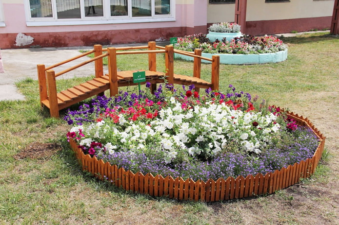 clôture en bois marron autour du parterre de fleurs