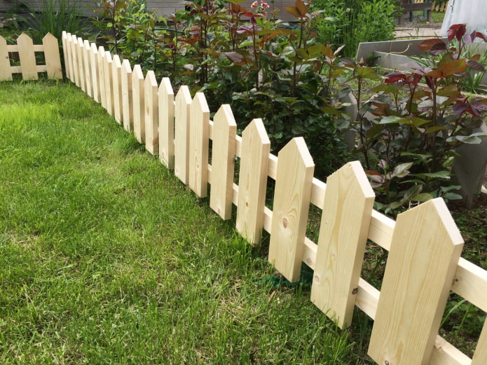 une clôture pour un jardin de fleurs à partir de planches fraîchement rabotées