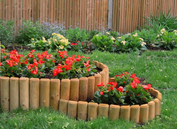 parterre de fleurs à deux niveaux avec un côté fait de piquets sciés en deux