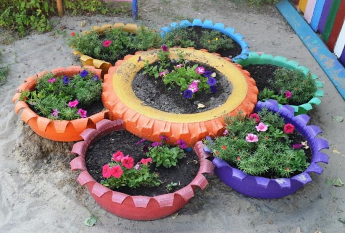 parterre de fleurs fait de pneus peints avec des dents sculptées