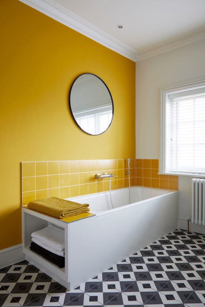 salle de bain avec mur jaune et sol en mosaïque noir et blanc