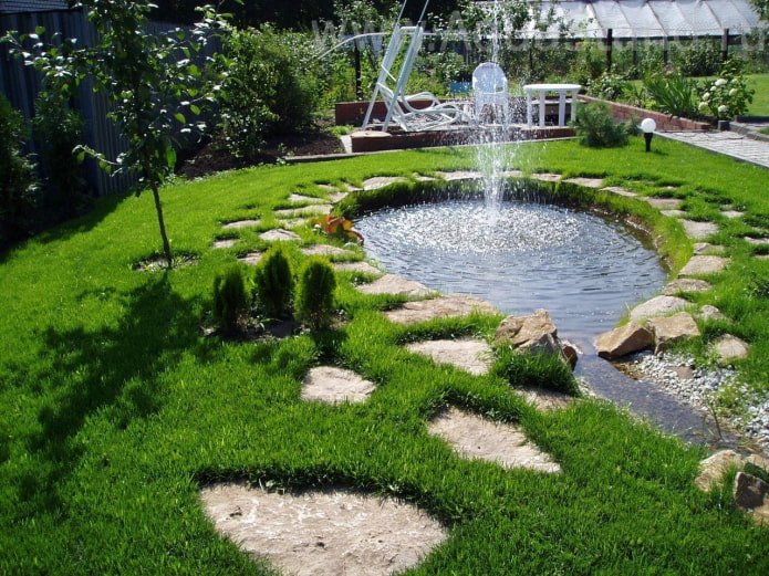 étang artificiel avec fontaine à la campagne